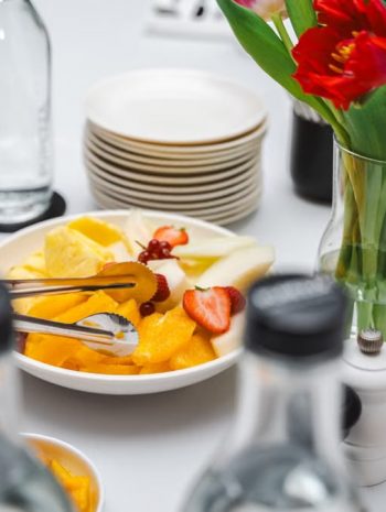 An elegant dining setup featuring fresh fruits and vibrant tulips, perfect for a healthy meal.